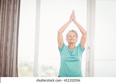 Senior Woman Performing Yoga At Home