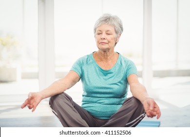 Senior Woman Performing Yoga While Sitting At Home