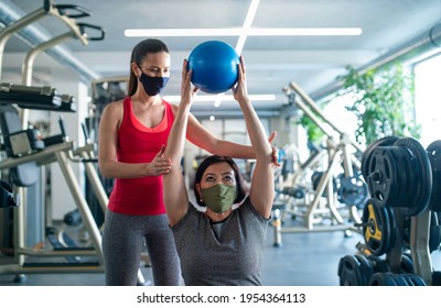 Senior Woman With Personal Trainer Doing Exercise In Gym, Coronavirus Concept.