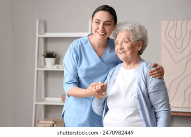 Senior woman with physical therapist hugging at home - Powered by Shutterstock