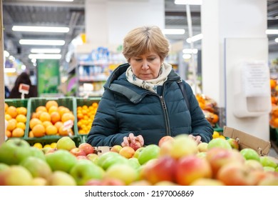 Senior Woman Picking Apple At The Grocery Shop



