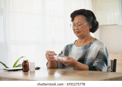 Senior Woman Picking Medication From Medicine Bag Put In A Daily Pill Organizer Box And Closing The Lids. Old Woman Taking Care Herself For Health. Health And Medical Concept.