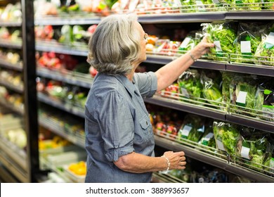 Senior Woman Picking Out Some Vegetables In Supermarket