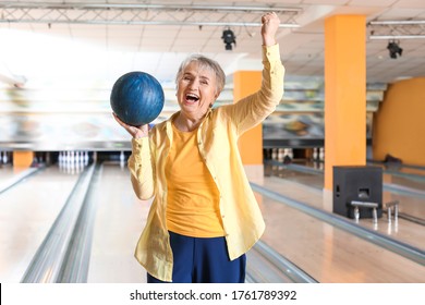 Senior Woman Playing Bowling In Club