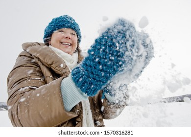 A Senior Woman Playing With Snow