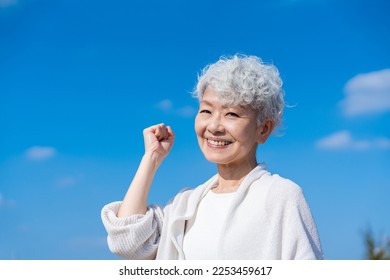 Senior woman posing with guts under the blue sky - Powered by Shutterstock