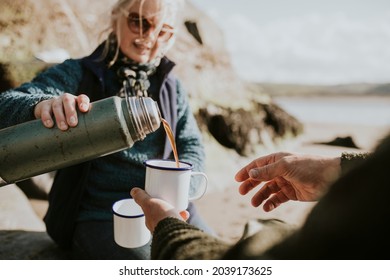 Senior Woman Pouring Coffee Into A Camping Mug