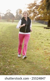 Senior Woman Power Walking In The Park