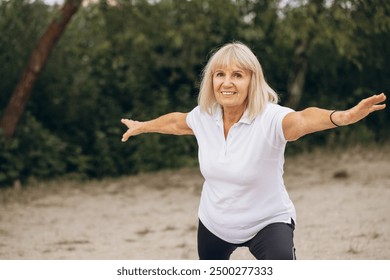 Senior woman practicing yoga outdoors, staying active and healthy in nature. Embracing fitness with positivity and energy. - Powered by Shutterstock