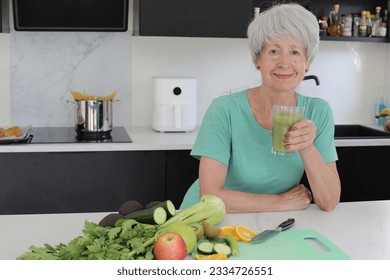 Senior woman preparing a green natural smoothie  - Powered by Shutterstock