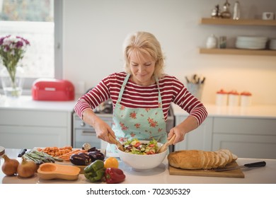 Senior Woman Preparing Meal In Kitchen