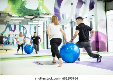 Senior Woman With PT Exercise With Ball In Gym