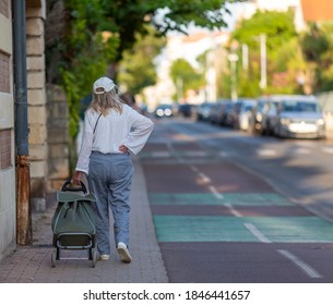 senior woman pulling a trolley bag - Powered by Shutterstock