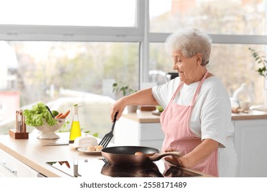 Senior woman putting fried cottage cheese pancakes on plate in kitchen - Powered by Shutterstock