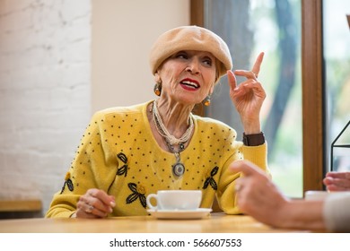 Senior Woman Raising Finger. Elderly Lady And Coffee Cup. I Know Better.