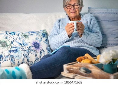 Senior Woman Relaxed On The Sofa With A Warm Cup Of Tea, Winter Concept - Wooden Tray With Sweet Food