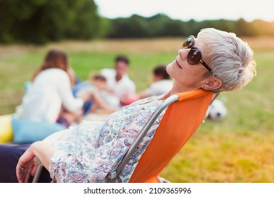 Senior Woman Relaxing In Chair In Field