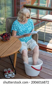 Senior Woman Relaxing Reading Book And Soaking Feet In The Cold Water. How To Stay Cool In Hot Weather. Beat The Heat.