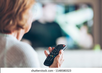 Senior Woman With Remote Control Watching Television