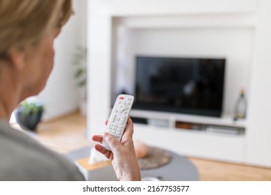Senior Woman With Remote Control Watching Television