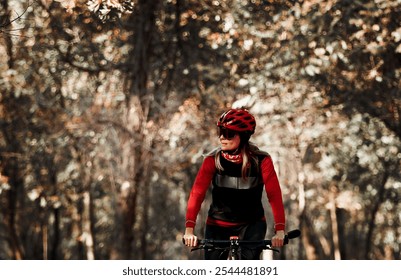 Senior woman riding a gravel bicycle in forest on a autumn sunny day.  - Powered by Shutterstock