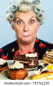 Senior Woman with Rollers in her Hair, indulging in her Guilty pleasure of eating too many cakes / Sweets: What? Who, me?!