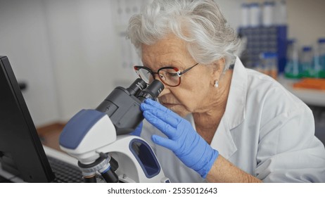 Senior woman scientist examining specimen through microscope in laboratory setting. - Powered by Shutterstock