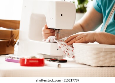 Senior woman sewing at home. 