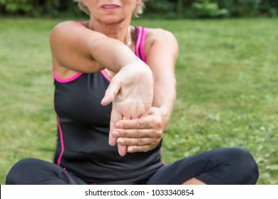 Senior woman is showing exercise for pain relief. Forearm Stretching for Carpal Tunnel Syndrome Pain Relief Treatment