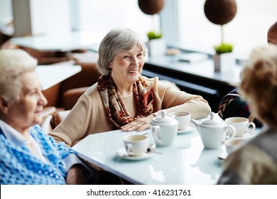 Senior Woman Sitting In Cafe With Friends