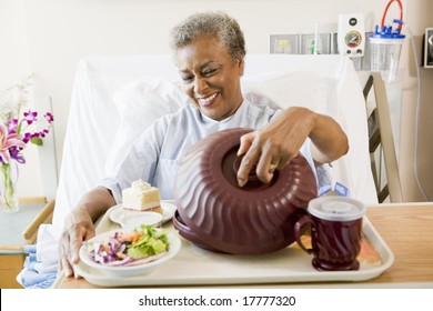 Senior Woman Sitting In Hospital Bed With A Tray Of Food