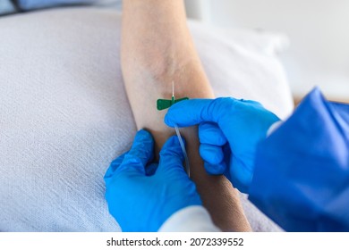 Senior Woman Sitting In The Hospital Chair While Receiving IV Infusion In Medicine Center