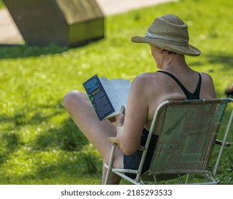 Senior Woman Sitting On Beach Chair On The Beach And Reading A Book. Elderly Lady Resting By The Sea Relax And Enjoy Outdoor Lifestyle Activity In Summer Vacation-July 26,2022-Cultus Lake BC Canada