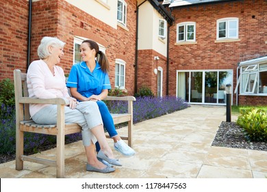 Senior Woman Sitting On Bench And Talking With Nurse In Retirement Home - Shutterstock ID 1178447563