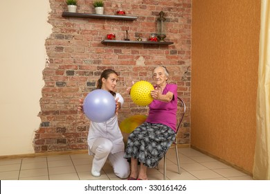 Senior Woman Sitting On A Chair And Holding Spiky Ball During Physiotherapy