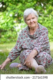 Senior Woman Sitting On Grass In Park. MANY OTHER PHOTOS FROM THIS SERIES IN MY PORTFOLIO. 