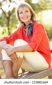 Senior Woman Sitting Outdoors On Bench