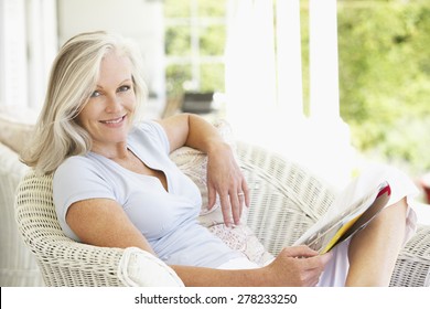 Senior Woman Sitting Outside Reading Magazine