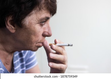 Senior Woman Sitting And Smoke A Cigarette