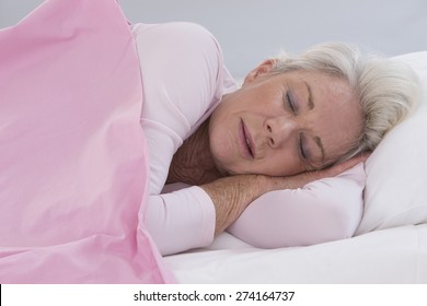 Senior Woman Sleeping On Bed