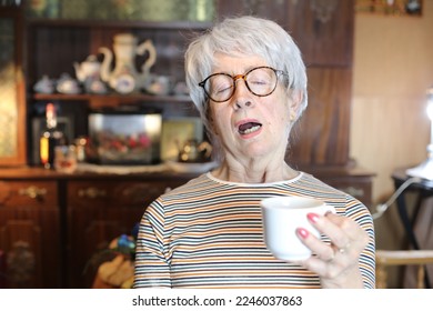 Senior woman sleeping while drinking coffee  - Powered by Shutterstock