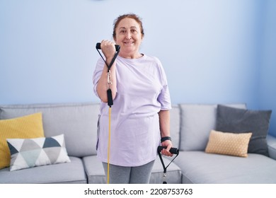 Senior Woman Smiling Confident Using Elastic Band Training At Home