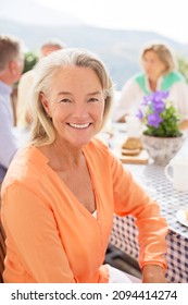 Senior woman smiling at patio table