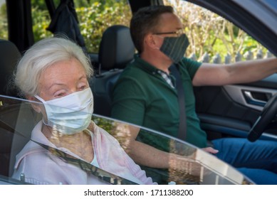 Senior Woman And Son With Face Mask Driving In The Car