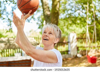 Senior Woman As A Sporty And Energetic Pensioner Playing Basketball In Summer