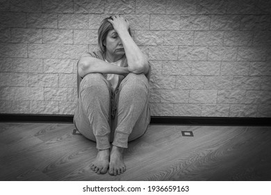 Senior Woman Stress Alone, Sad Sitting On The Floor In Depression. Concept Mental Health, Emotional Anxiety, Panic Attack. Sadness, Loneliness, Old Age. Social Documentary Concepts Black And White