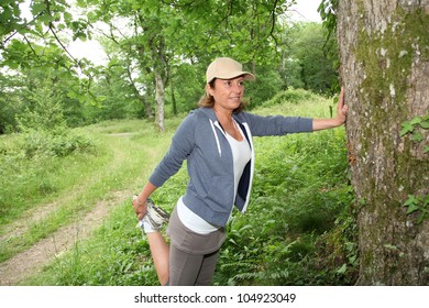 Senior Woman Stretching Out On Tree