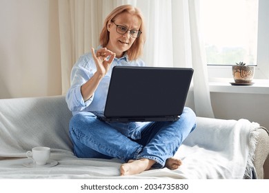 Senior woman studying online using laptop, at home, business, education online