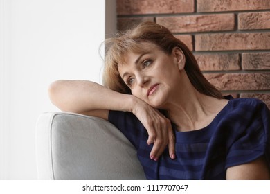 Senior woman suffering from depression in armchair