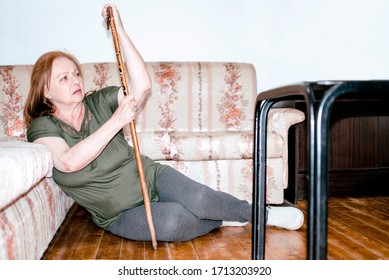 Senior Woman Suffering From Faint Lying On Floor After Falling Down At Home. Elderly Woman Fell On The Floor.Weak Elderly Woman With Walking Stick Trying To Get Up